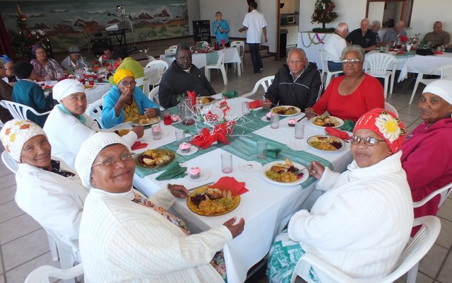 ‘n Gesellige oomblik aan tafel tydens die NG Vrouediens se Uitreikaksie se jaarlikse Kersete aan die bejaardes van Silwerjare Dienssentrum